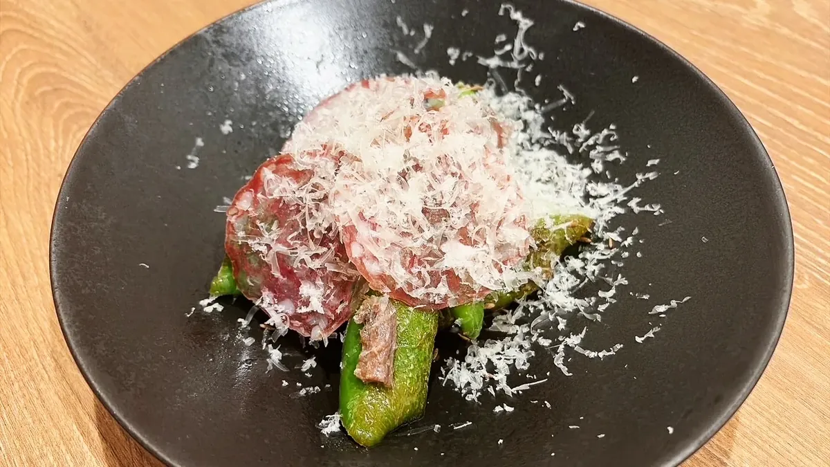 焼き万願寺とうがらしに白カビサラミと削りマンチェゴチーズをのせた一皿